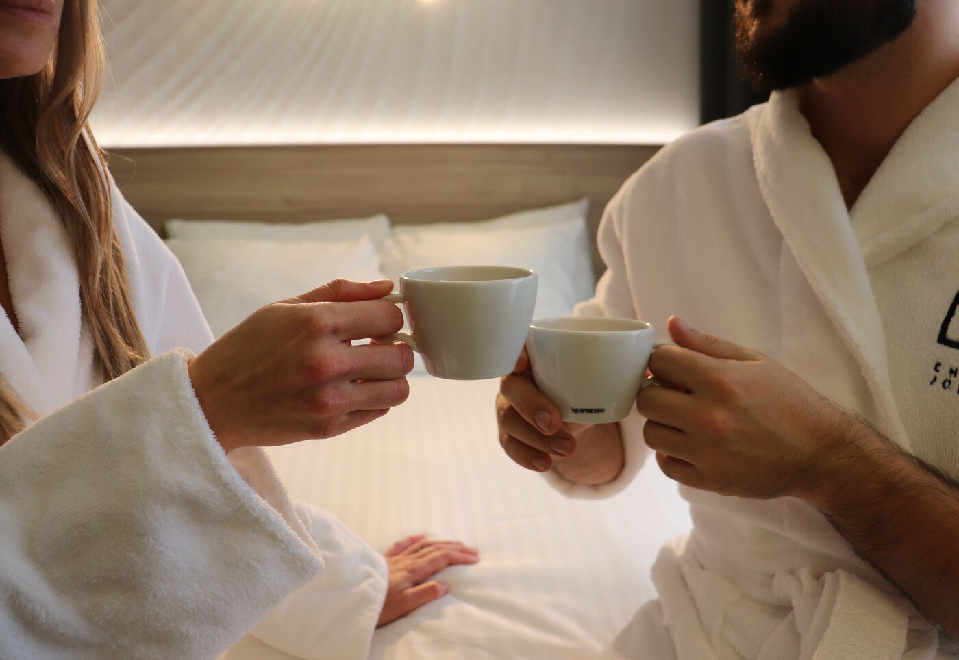 Couple enjoying coffee in bed at Hôtel Château Joliette